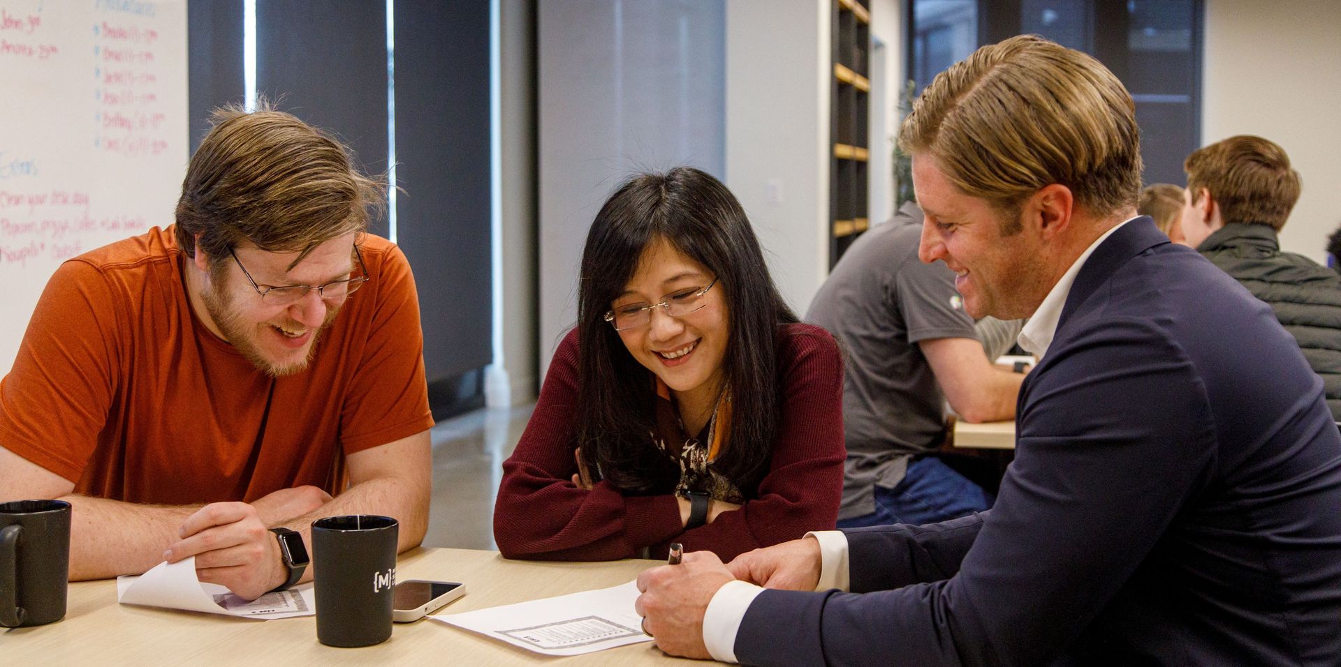 team members laugh around table