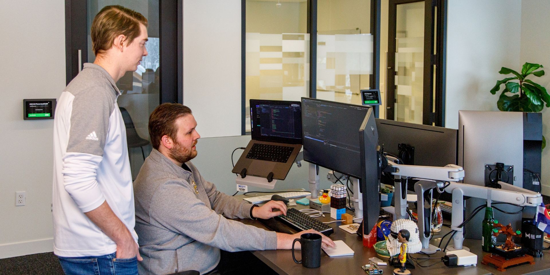 developers huddle around computer screens to review a project 