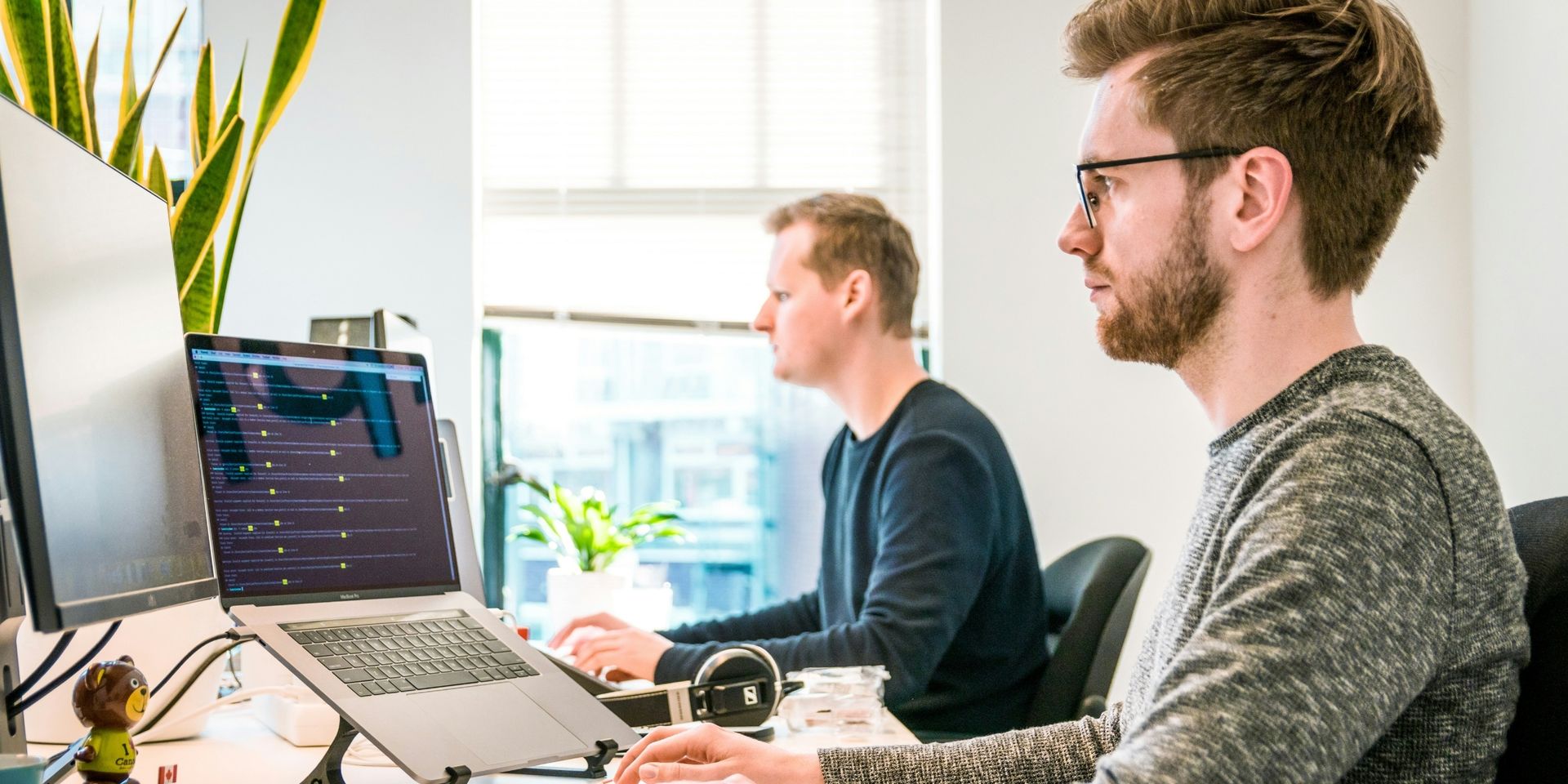 two male developers work on computers