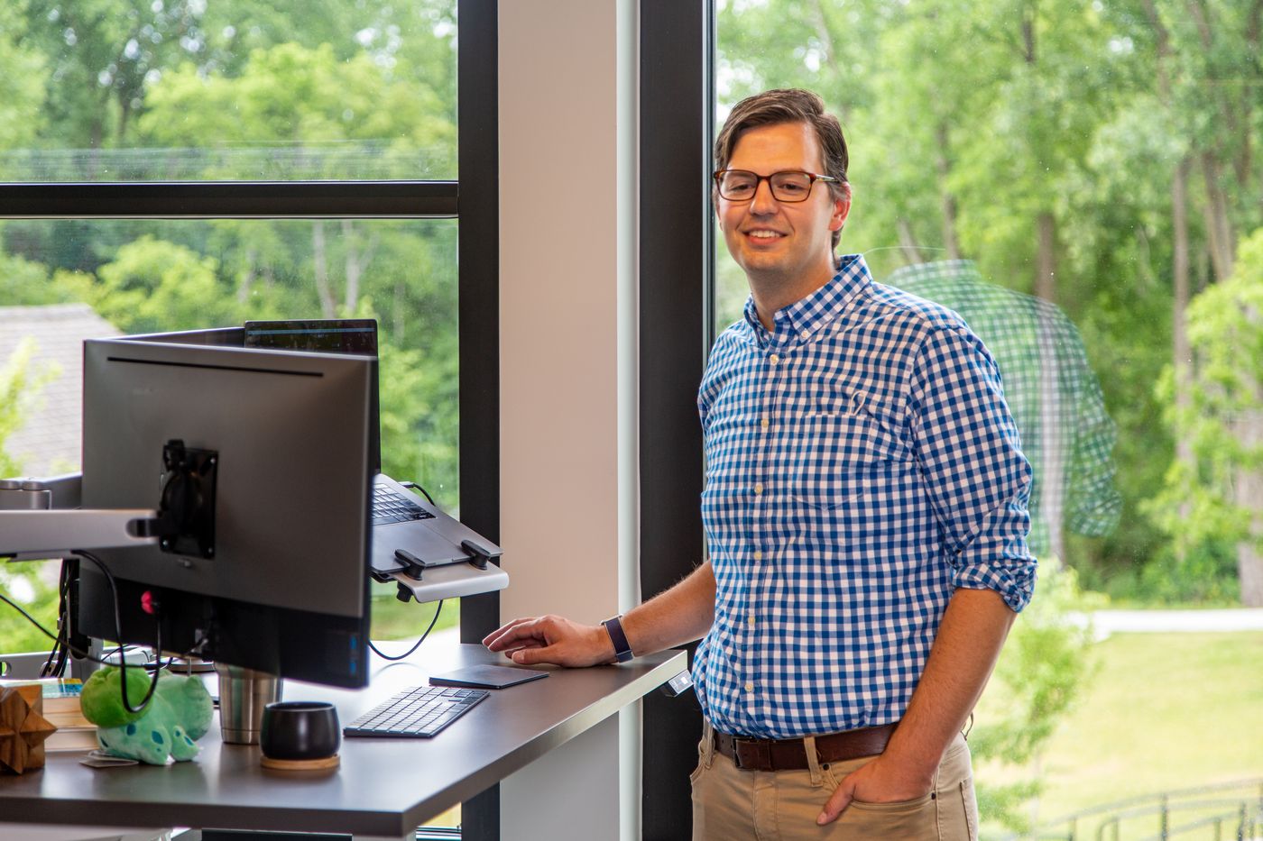 Man standing by desk with computer monitor