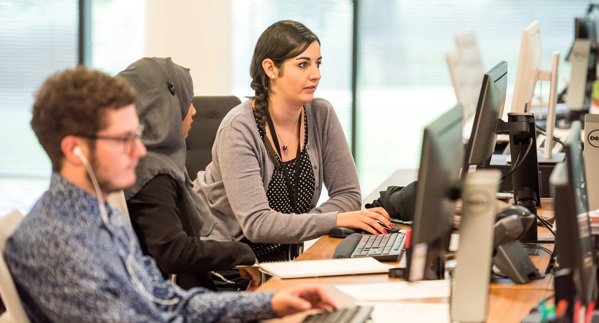 People sitting at a desk looking at a computer screen