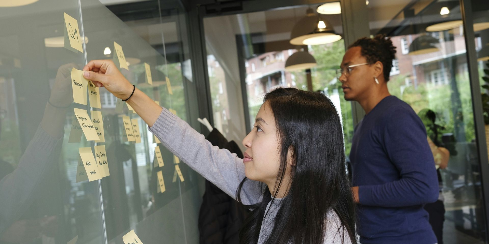 product managers move sticky notes on a whiteboard