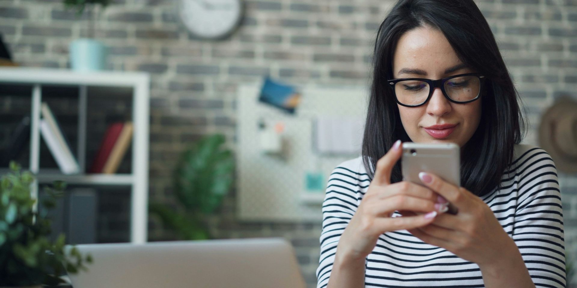 woman looks at her phone in a modern office