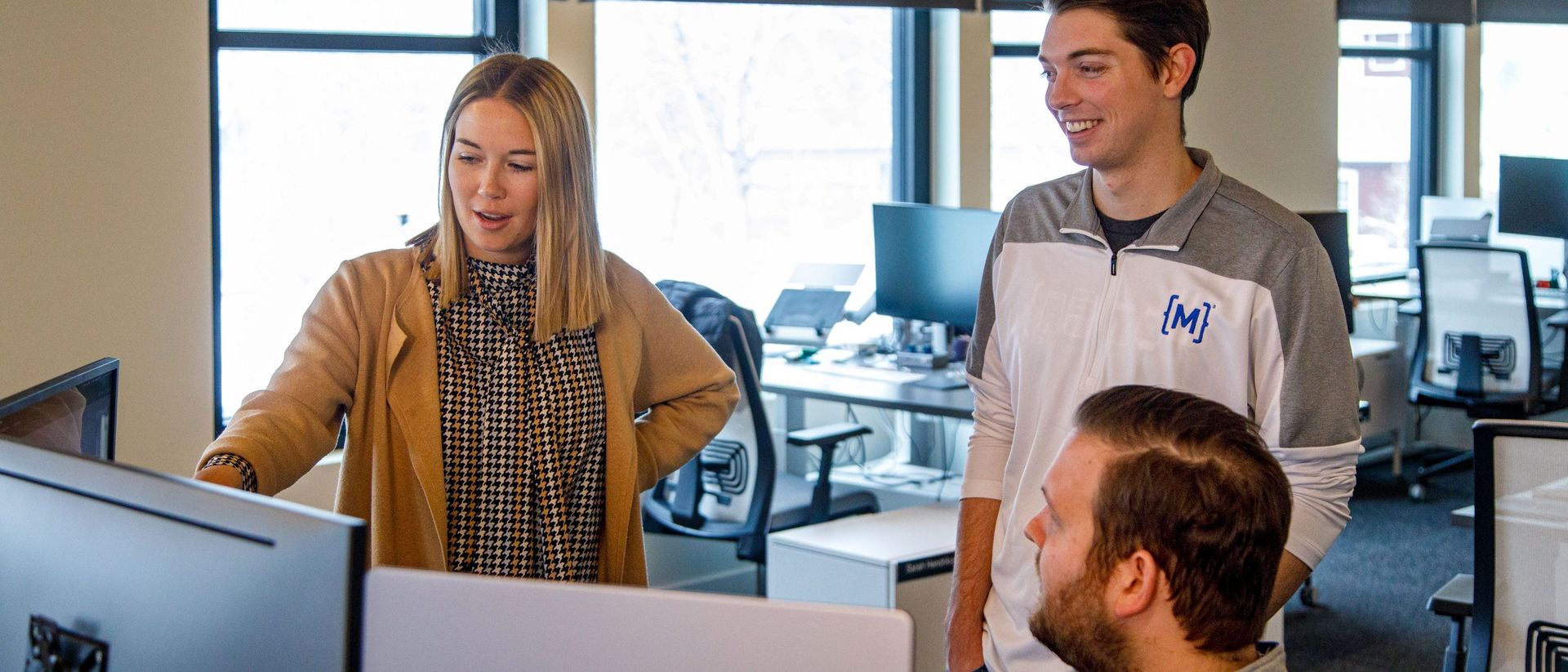 developers review code on desktop monitors