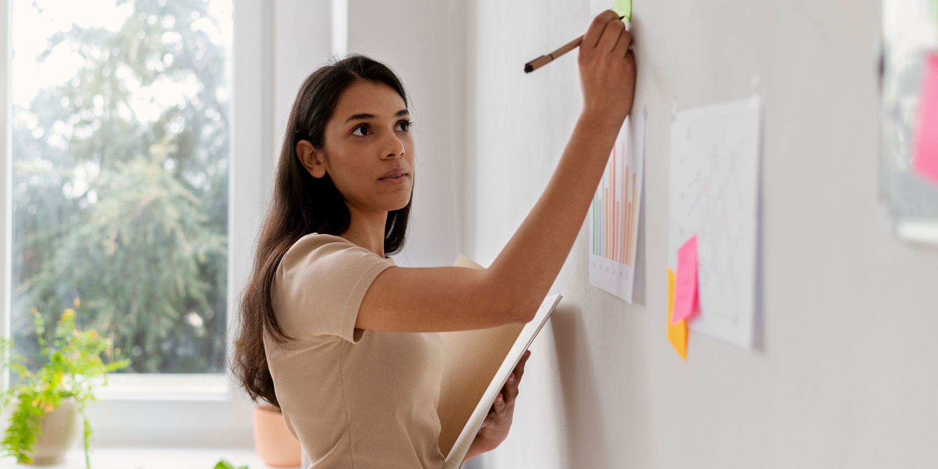 female strategist writes on whiteboard during a workshop