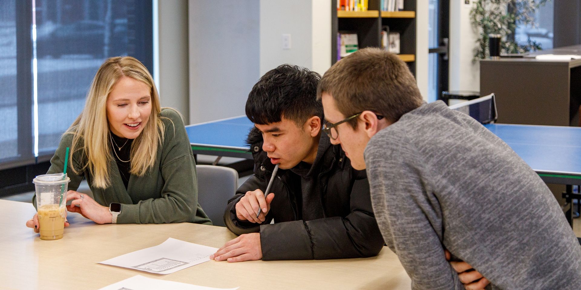 team members study a piece of paper on a table