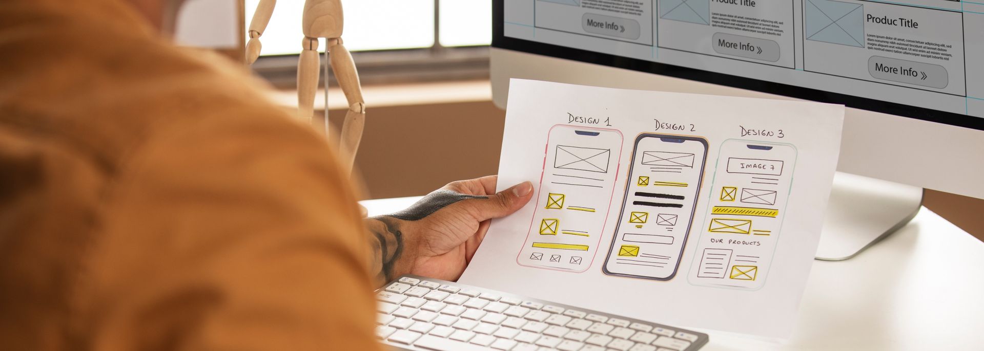 man holds a paper sketch of mobile UX options